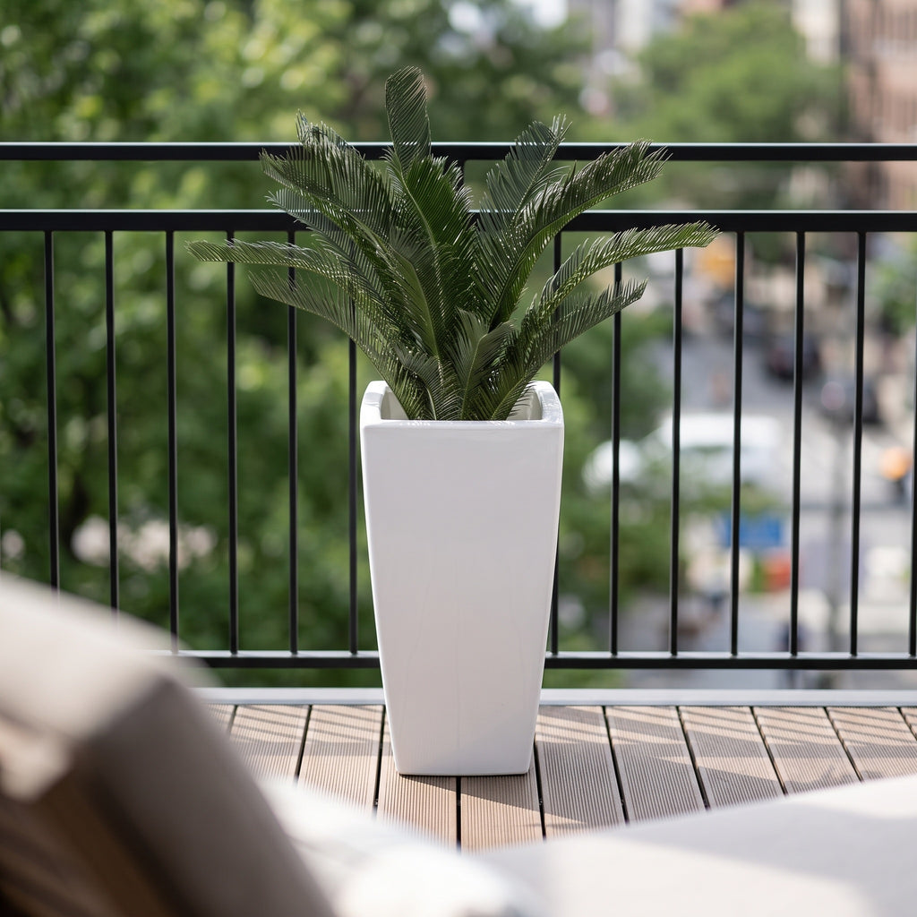 Cycas kunstpalm 80 cm in hoge witte pot op houten vlonder van een stadsbalkon met zwart hekwerk