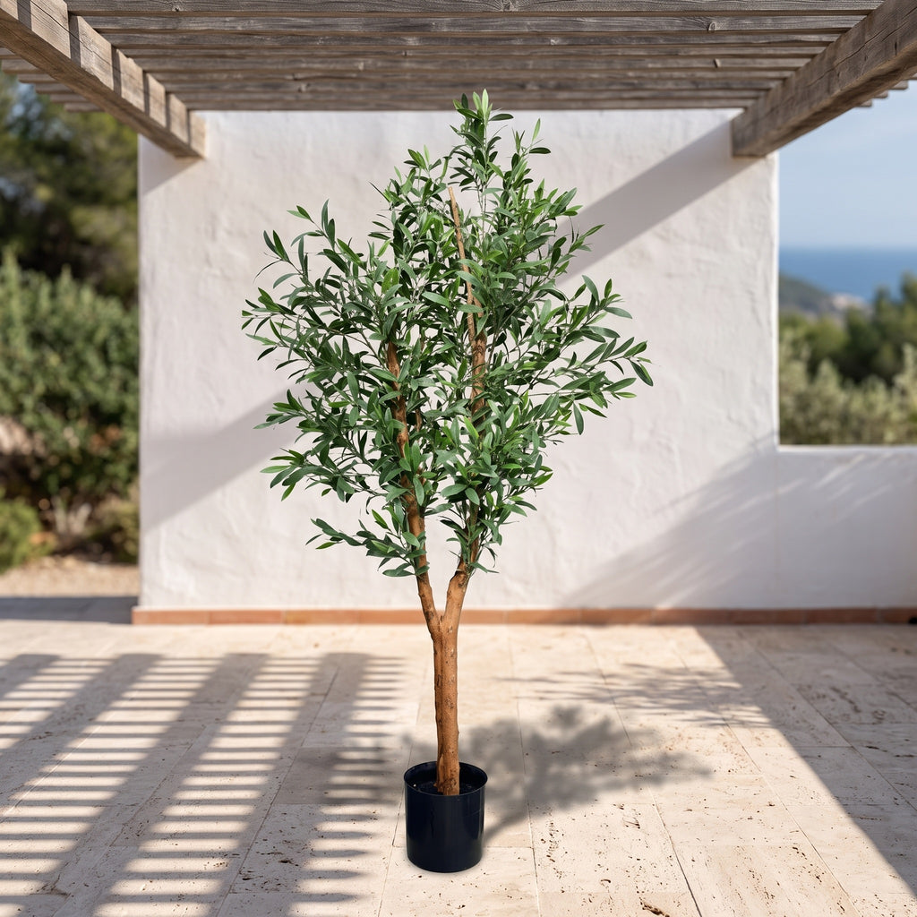 Kunst olijfboom 150 cm met hardhouten stam op een zonnig mediterraan terras onder een pergola